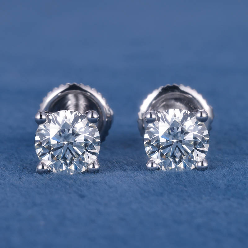 Par de aretes con piedras transparentes sobre fondo azul